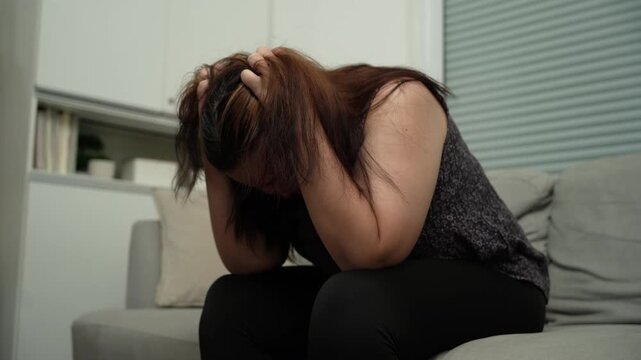 Sad Overweight plus size woman thinking about problems on sofa upset girl feeling lonely and sad from bad relationship or Depressed woman disorder mental health