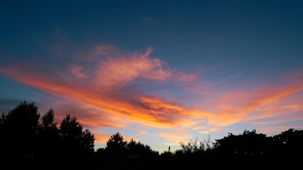 Sunset sky with orange clouds. View of orange clouds in the sky background. orange clouds illuminated by the setting sun