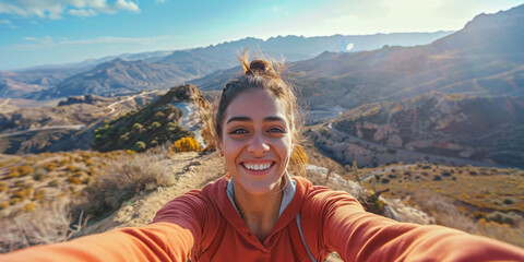 hispanic woman. A young woman smiles brightly in a selfie taken from a mountaintop, enjoying the scenic views and sunshine