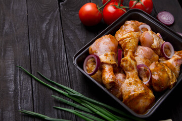 chicken legs marinated in seasonings on a black background