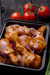 chicken legs marinated in seasonings on a black background