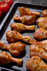 chicken legs marinated in seasonings on a baking sheet