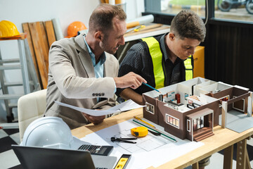 Architecture and teamwork concept. Male engineers or business partners on a construction site, discussing project details.