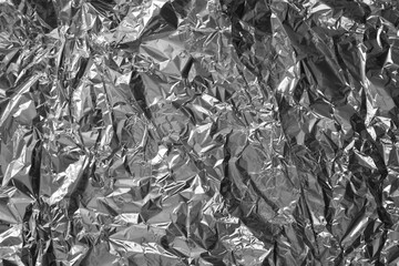Processed collage of shiny metal silver gray foil crumpled packaging material texture