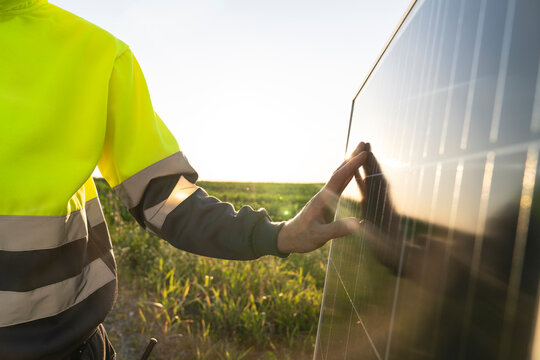 Hand of engineer touching solar panel on sunny day