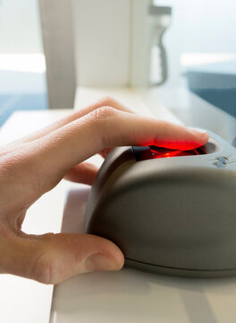Hand of woman using fingerprint scanner at data center
