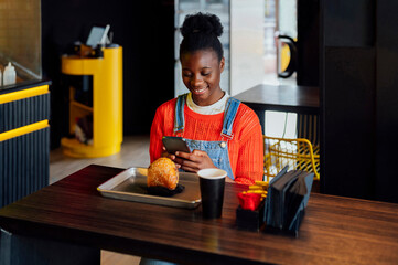 Young woman using smart phone in restaurant
