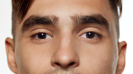 Close-up photo of male eyes, thick eyebrows against white studio background. Preorbital zone with...