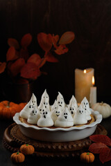 Delicious homemade pie for Halloween with a filling of pumpkin decorated with ghost for kid's party. Vertcal
