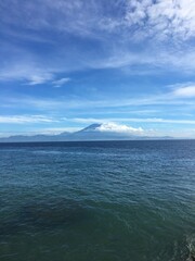 Mountain Above the Ocean in the Clouds with Clear Water During Daylight