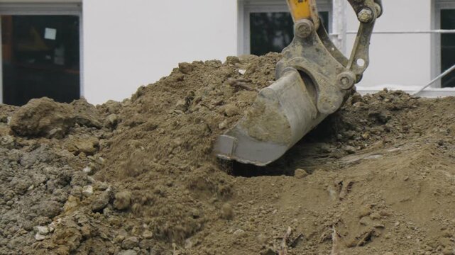 Pelleteuse prenant de la terre dans son godet. Excavator taking up soil in its bucket.