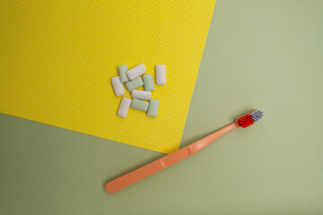 Toothbrush and chewing gum lie on a colored background. Time to brush your teeth. Top view, flat lay. Dental health concept