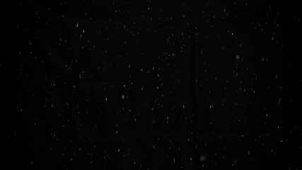 Snow on black background, slow motion, falling snowflakes, snowing, natural snowfall backdrop for overlay effect.

