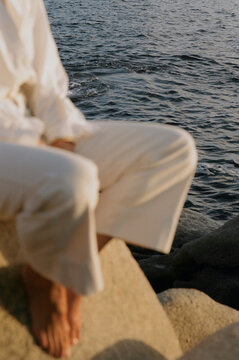 Close up of woman in white sat by the water