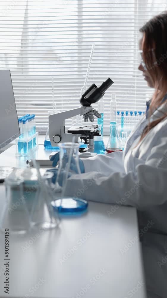 Poster a female scientist conducting experiments in a laboratory, using a microscope and test tubes for her