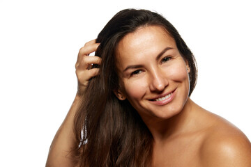 Fototapeta premium Close up photo of beautiful woman with long, brunette hair posing looking at camera against white studio background. Concept of beauty, haircare treatments and cosmetology products, hairstyle,