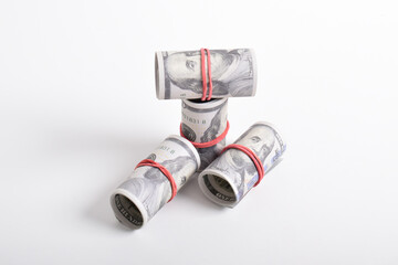 Bundle of money roll of dollars isolated on white background. One hundred dollar American cash rolled with red rubber. U.S. dollars. $100 bills