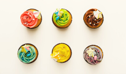 Top view on set of vanilla cupcakes with colorful buttercream tops isolated on white background....