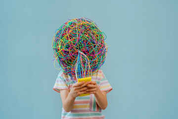 Girl with mask of chaotic thoughts using smart phone against blue background