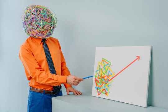 Businessman with mask of chaotic thoughts explaining progress diagram near blue background