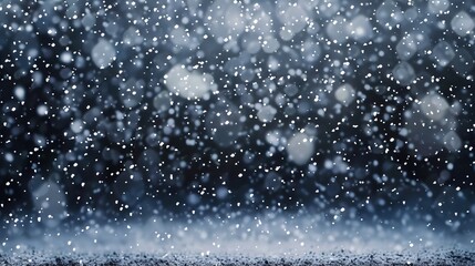 Obraz premium The image depicts delicate snowflakes gently falling against a dark, black background. 