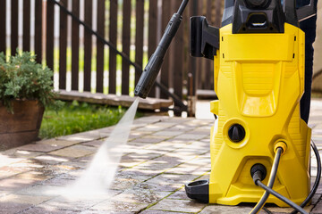 Washing Paving Stone Floor in Garden. Home and Garden Pressure Washer. Cleaning Equipment. Electric Power Pressure Washer for Cleaning Garden Furniture. 