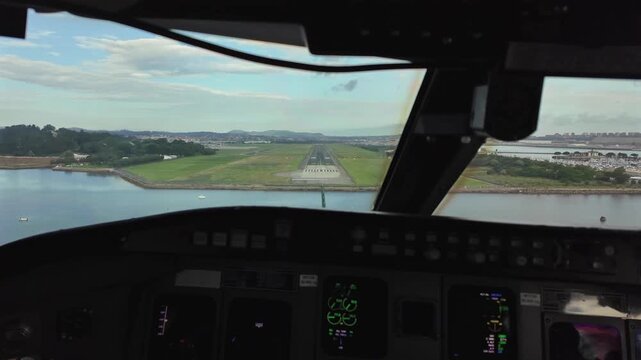 A real time landing at coastal Santander airport in Spain, as seen by the pilots inside the cockpit. Partially clouded sky. 4K 60FPS