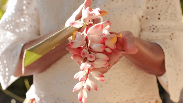 Woman Holding Alpinia Zerumbet On Her Hands - Close Up