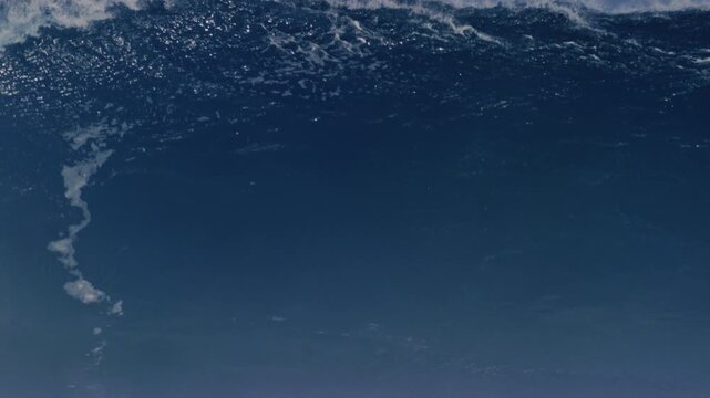 Frontal view of shimmering whitewash water crashing as wave breaks into heavy barrel, Cloudbreak Fiji