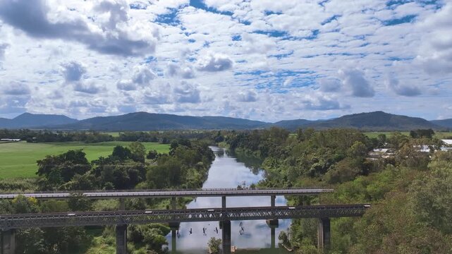 Flight rises up above and over the rail and road bridges on the Pioneer River by Mirani in Australia's Mackay region. Grand views up the river towards Mount Martin National Park and Mount Toby.