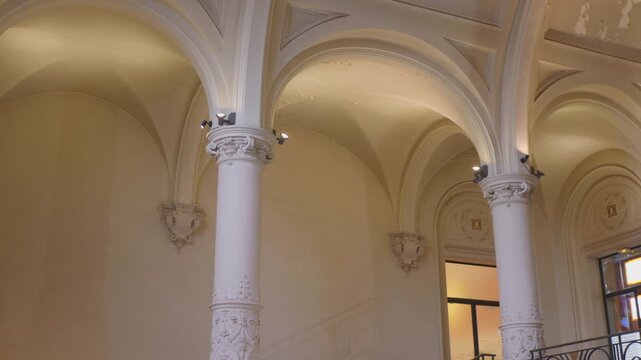 Elegant arches and columns inside Dunkirk Town Hall, France, lit with warm lighting