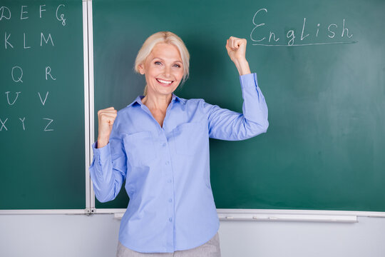 Photo of cheerful glad senior woman wear shirt pass test yes isolated on green board background - Powered by Adobe