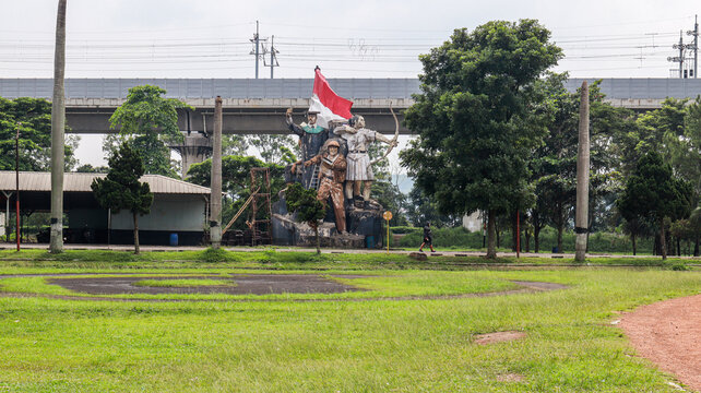 Cimahi, Indonesia - July 13, 2024: A statue of three figures stands tall under a highway overpass a reminder of history amidst modern infrastructure. Monument of Four Figures with Indonesian Flag.