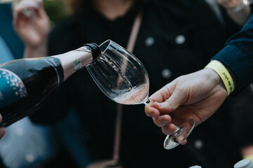 We celebrate the evening with white wine and roses in glasses, giving cheers at a restaurant, relaxed and full of joy.