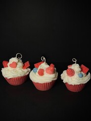 Candle cupcakes with icing, strawberry, blueberry and chocolate. Scented soy candles on the black...