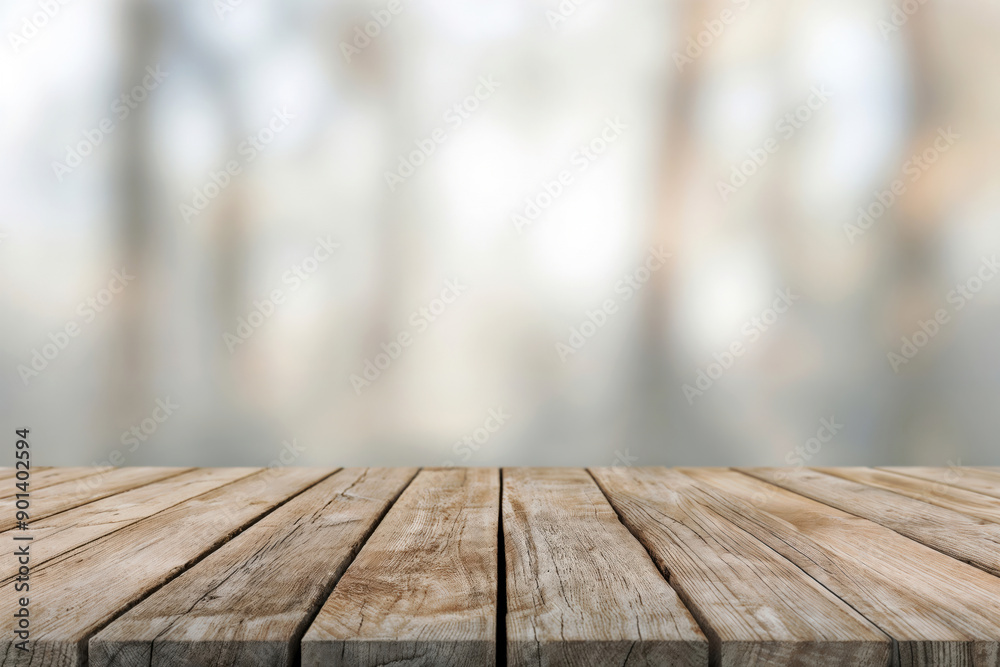 Wall mural empty wooden tabletop with blurred abstract trees background for displaying products