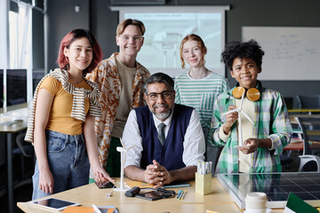 Group portrait of mature teacher of Environmental Education and multi-ethnic students posing for camera during lesson