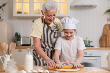 Happy family in kitchen. Grandmother and granddaughter child cook in kitchen together. Grandma...