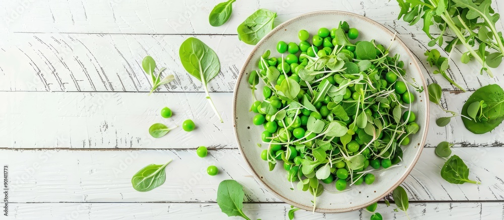 Poster top view of a vegetarian green pea salad with microgreens and vegetables on a white wooden surface p