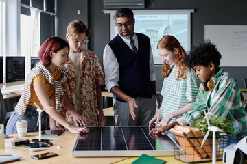 Medium long shot of teacher of Environmental Education speaking about solar energy and PV modules...