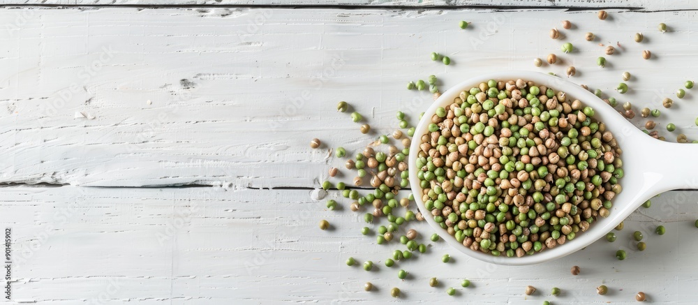 Poster top down view of raw green buckwheat grains in a spoon on a white wooden surface with room for text 