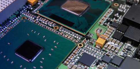 Detailed closeup of an electronic circuit board showcasing microchips, resistors, and other components, representing modern technology and hardware.