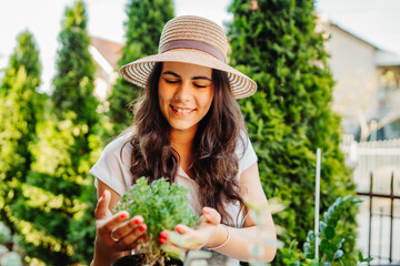 Young woman taking care of plants with water can and mister