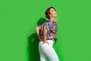 Photo of adorable excited lady dressed print shirt laughing empty space isolated green color background