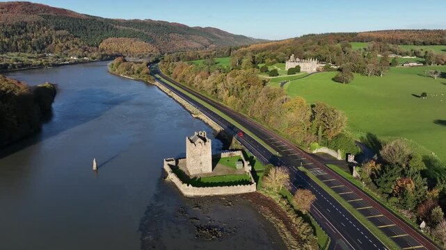 Narrow Water Castle, County Down, Northern Ireland, November 2022. Drone orbits the Tower House surrounded by Autumn foliage with 19th Century Elizabethan Revival Castle in the background.