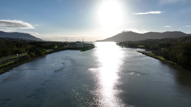 Warrenpoint Port, County Down, Northern Ireland, November 2022. Drone pushes south east above Newry River along the Irish border on a bright winter morning with Carlingford Lough in the background.