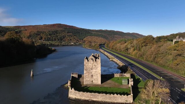Narrow Water Castle, County Down, Northern Ireland, November 2022. Drone orbits the stone Tower House on the banks of the Newry River while descending clockwise on a bright sunny winters morning.