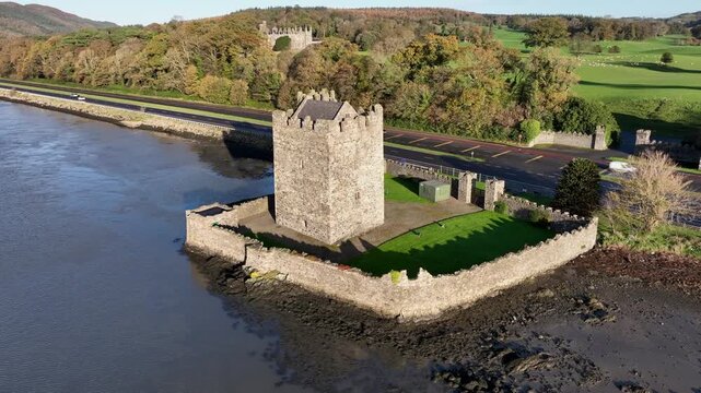 Narrow Water Castle, County Down, Northern Ireland, November 2022. Drone orbits the Tower House counter clockwise on the Newry River with the 19th Century Elizabethan Revival Castle in the background.