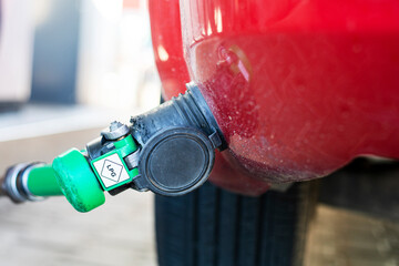 filling up a red car with LPG at a universal gas station. Economic crisis. rising prices for oil...