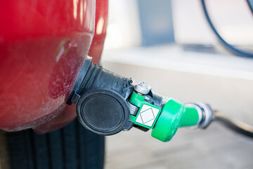 filling up a red car with LPG at a universal gas station. Economic crisis. rising prices for oil...